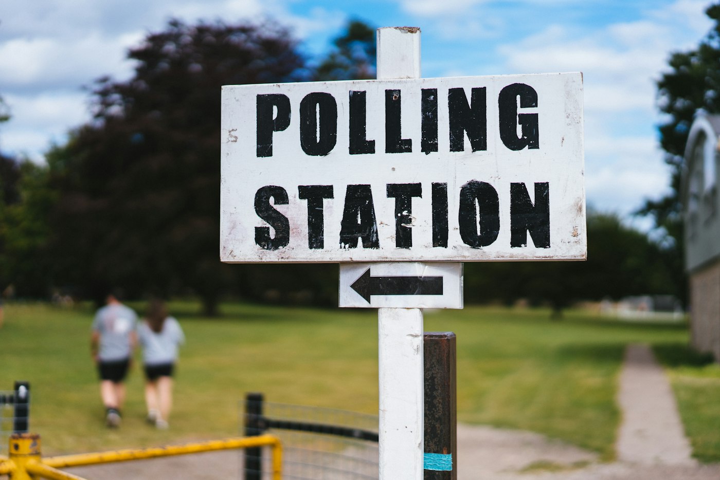 A polling station sign on a village green in England