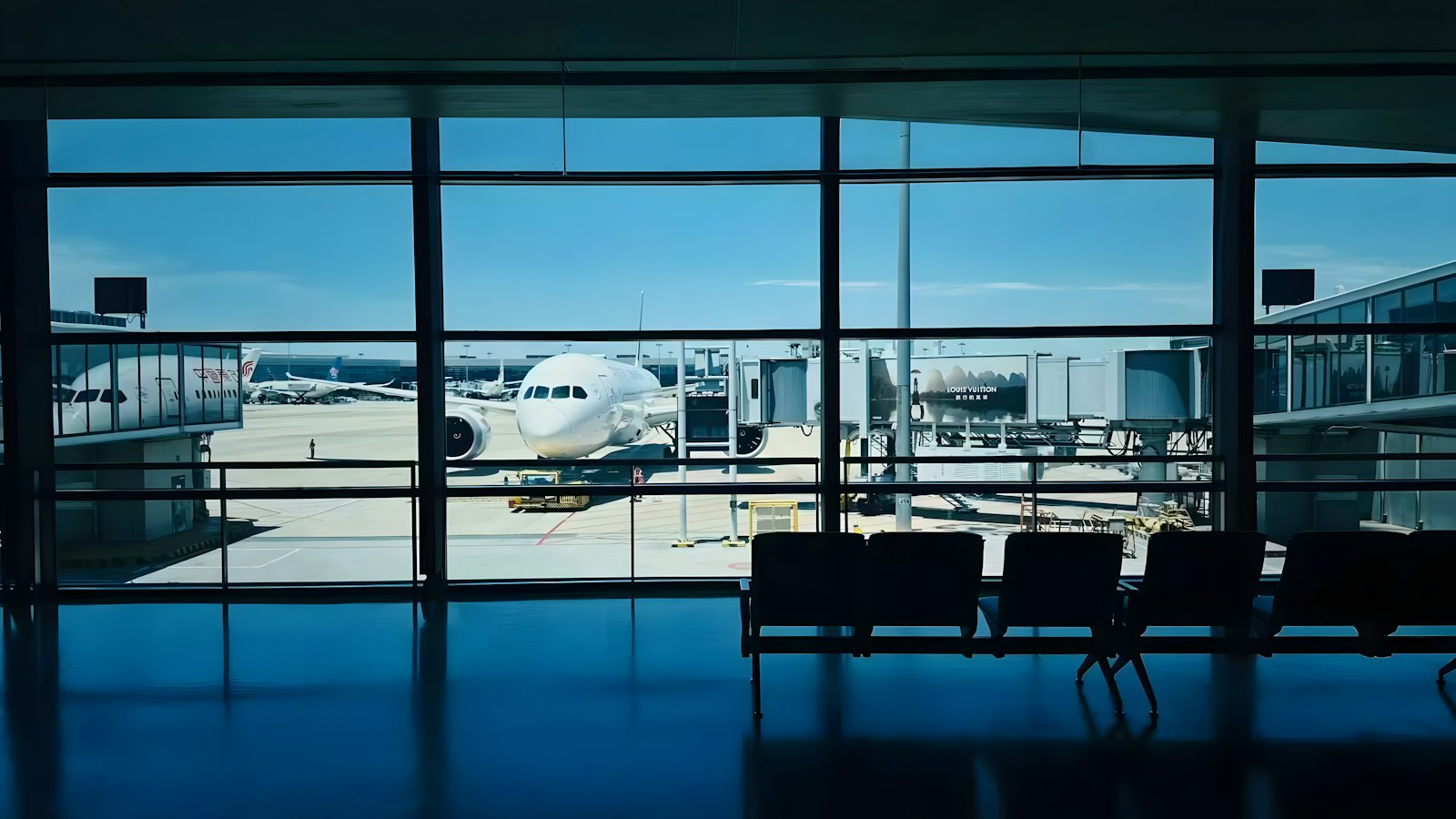 An airliner at the gate, seen from an empty departure lounge