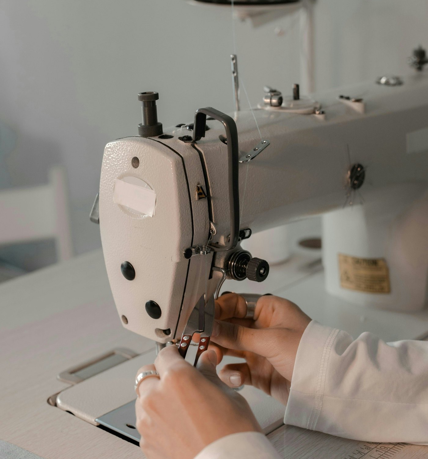 Hands guiding fabric through an industrial sewing machine